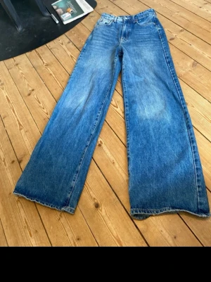 Blåa wide leg jeans - Vida byxor i bra skick. Tycker de sitter väldigt snyggt på Midja: 35cm x 2 Innerbenslängd: 80cm Benvidd nertill: 27cm