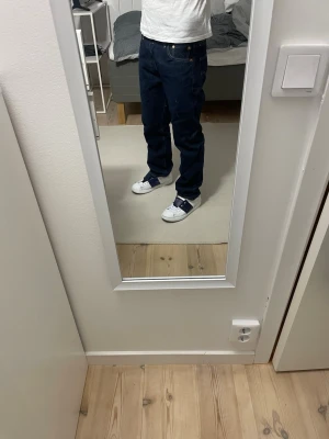 Levi’s 501 - Säljer ett par mörkblå jeans från Levis med rak passform och klassisk femficksdesign. Jeansen har en snygg tvätt och är tillverkade i mjukt denimtyg med lite stretch för extra komfort. Perfekta till en avslappnad stil.