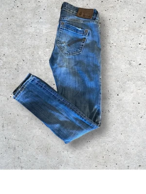 Blå dondup jeans  - Säljer ett par blå jeans från dondup med snygga slitningar och tvättade detaljer. Klassisk femficksmodell med normal midja och raka ben. Jeansen är gjorda i bomull och har en cool, avslappnad look som passar perfekt till vardagsoutfits.