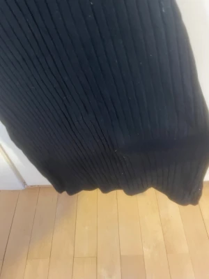 Svart ribbad stickad klänning - Den är storlek 146-152 , men jag tycker den är 152-164. Säljer en svart ribbad stickad klänning med smala axelband och rak passform. Klänningen är figurnära och har en enkel, stilren design som passar perfekt till olika tillfällen. Materialet är mjukt och stretchigt för en bekväm känsla.