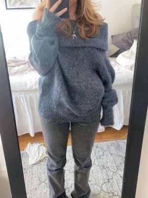 Mörkgrå off shoulder stickad tröja - Mysig mörkgrå stickad tröja med off shoulder-krage och långa ärmar, den säljs inte längre. Tröjan har aldrig kommit till användning. Perfekt tröja till vinter/ vår. (inte min bild) 