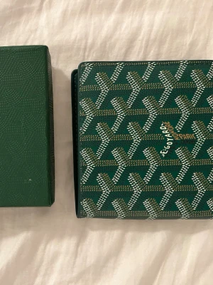 Grönplånbok med mönster - Snygg grön plånbok. Plånboken har flera kortfack och är tillverkad i läder. Perfekt för dig som vill ha en exklusiv och unik accessoar.kom privat för mer info