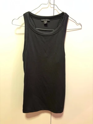 Svart linnetopp från Amisu stl L - Säljer en svart linnetopp från Amisu med breda axelband och rund halsringning. Toppen är ärmlös och har en enkel, stilren design som passar till det mesta. Materialet känns mjukt och stretchigt, perfekt för varma dagar eller som lager under en skjorta.