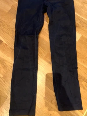 Louis Vuitton chinos. - Snygga mörkblå Louis Vuitton chinos med rak passform och klassisk design. Byxorna har diskreta sömmar och är tillverkade i ett mjukt, vävt material som ger en clean look. Perfekta för dig som gillar stilrena plagg.