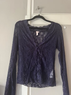 Spetsblus från Nelly - Snygg mörkblå långärmad blus från Nelly i  spets med v-ringning och fina spetsdetaljer.