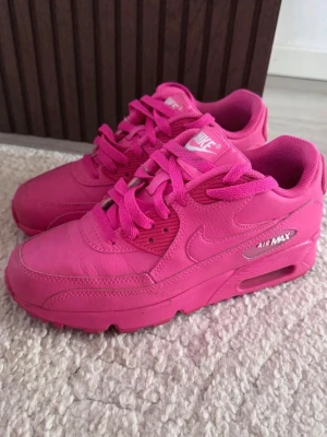 Nike Air Max 90 helrosa sneakers - Nike Air Max 90 sneakers i en riktigt fet helrosa färg. Klassisk modell med synlig Air Max-dämpning i sulan, sköna och snygga detaljer samt Nike-logga på sidan och hälen. matchande rosa snören och sula. Storlek 37,5. Det är använda ca 5gånger så nästintill nya men som ni ser på bilderna är det tecken på användning 