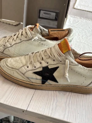 Golden Goose ballstar - Golden Goose sneakers i vitt läder med mörkblå stjärna i krokodilmönster på sidan och orange detalj på plösen. Modellen ballstar i storlek 44, allt og!