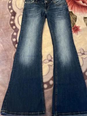 Y2K blazed jeans  - Jag säljer blåa Y2K blazed jeans från lager 157, väldigt lågmidjat och sitter jätte bra. Andvänt den några gånger men den är som ny. Den är i storlek M men kan också passa dig som har storlek S 