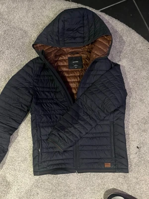 Jacka marinblå/grå - Ovanlig och sjukt premium jacka från Jack & Jones som ja tror köptes för runt 1299kr. Perfekt till våren och skicket är som nytt. Han på bilden är 184 och sitter utmärkt på han.