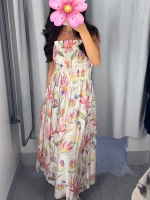 Klänning sommar - Säljer en superfin långklänning med blommigt mönster i pastellfärger och små fåglar. Klänningen har smock upptill, tunna axelband och en luftig, flowy kjol. Perfekt för varma dagar och ger en romantisk vibe.