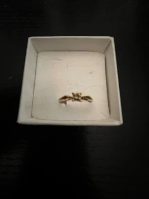 Äkta guldring 18k ring med grön ädelsten - Äkta guldring med en liten grön ädelsten i mitten. Liten storlek, ca 14-15. Aldrig använd. Köptes för ett par år sedan, kvitto saknas därav lägre pris.