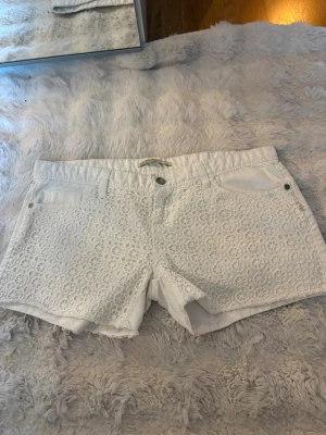 Vita spetsdetaljerade shorts - Säljer ett par vita jätte söta shorts i storlek M ifrån stradivarius. I modellen är de ganska korta och lågmidjade💕💕