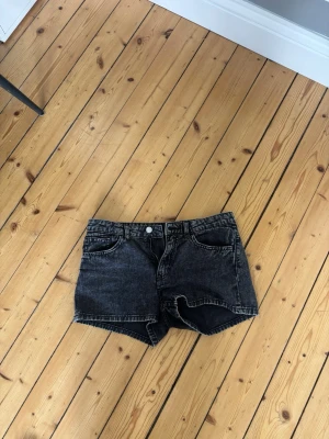 Svarta denimshorts med hög midja - Snygga svarta denimshorts med medel hög midja. Perfekta till sommaren och lätta att matcha med olika stilar.