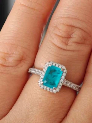 Silverring med blå sten och små kristaller  - Snygg silverring i äkta 925 silver med en rektangulär blå sten i mitten, omgiven av små gnistrande kristaller. Ringen har även små stenar längs bandet för extra bling. Perfekt för dig som gillar färg och vill sticka ut.