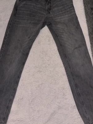 Gråa jeans - Snygga grå jeans med rak passform och klassisk femficksdesign. Jeansen har en tvättad look och är tillverkade i denim. Perfekta för en avslappnad och trendig stil.