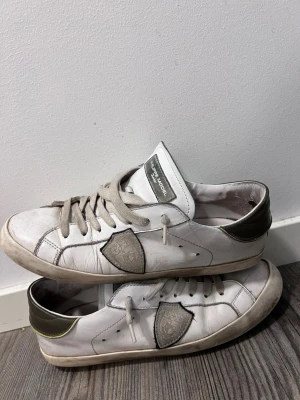 Philippe Model - strl. 39 - Säljer mina Philippe Model Junior då de inte används längre. Skorna är använda och har normalt slitage. Ovandelen i läder är fortfarande i fint skick, men det finns slitage på sulorna och mindre hål vid tå/häl (se bilder). Därför säljs skorna i befintligt skick. Storlek: 39 Pris: 800 kr Skicka gärna meddelande vid intresse eller frågor.