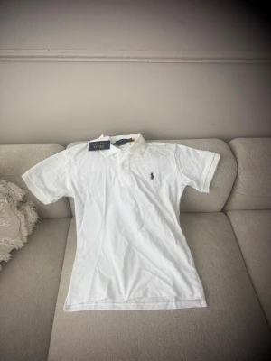 Vit piké Polo Ralph Lauren - Helt ny oanvänd Ralph lauren Piké perfekt inför sommaren  Storlek S hör av er snabbt.