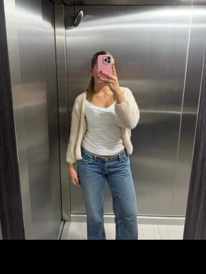 Blå raka jeans med hög midja - Säljer ett par klassiska blå jeans med rak passform och hög midja. Jeansen har fem fickor, bälteshällor och stängs med dragkedja och knapp. Perfekta till en avslappnad look och passar till det mesta. Materialet är denim i bomull.