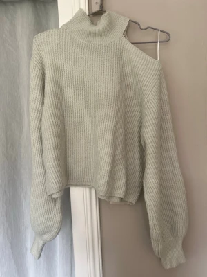 Ljus stickad tröja med cut out Gina Tricot - Trendig ljus stickad tröja från Gina Tricot med hög krage och cut out-detalj på ena axeln. 