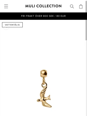 Guld charm med fågel  - Snyggt charm i guldton från Muli Collection med en fågel. Detaljerna ger en trendig och personlig touch. Perfekt för dig som gillar stilrena accessoarer med unika detaljer.
