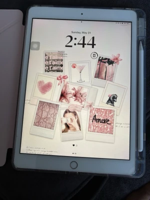 Apple iPad med penna och fodral - Säljer en Apple iPad i guld med vit framsida. Medföljer genomskinligt skyddsfodral och en vit styluspenna. Surfplattan har en stor skärm och klassisk Apple-design med rundade hörn och hemknapp. Perfekt för både skolarbete och underhållning.