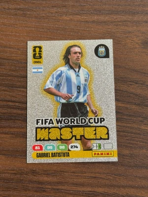 Panini FIFA World Cup Master kort - Samlarbild från Panini Adrenalyn XL FIFA World Cup 2026 med Gabriel Batistuta och fler. Kortet har glittrig silverbakgrund, svart och gul text samt argentinsk landslagströja. Perfekt för dig som gillar fotboll och samlarkort. Pris kan diskuteras 