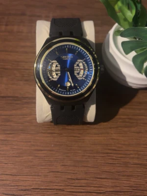Klocka  - Snygg klocka med blå urtavla, svarta detaljer och guldfärgad ram. Klockan har svart silikonarmband och flera små urtavlor för extra funktioner. Perfekt accessoar för dig som gillar stilrena detaljer. Priset kan diskuteras!