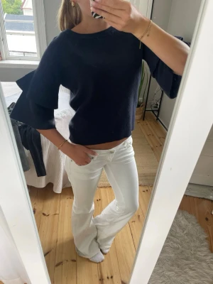Mörkblå tröja med volangärm - Säljer en mörkblå tröja med rund hals och trendiga volangärmar. Så söt tröja som är unik!!