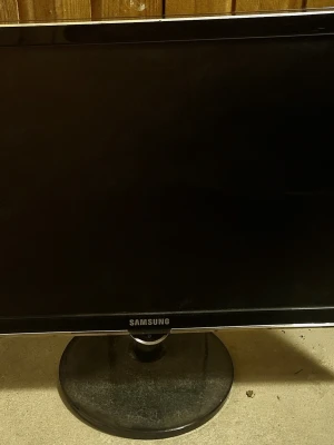 Samsung datorskärm svart - Säljer en svart Samsung datorskärm med rund fot. Skärmen har HDMI- och DVI-ingång samt strömanslutning på baksidan. Perfekt för gaming, film eller plugget. Klassisk design i plast med diskret Samsung-logga på framsidan.