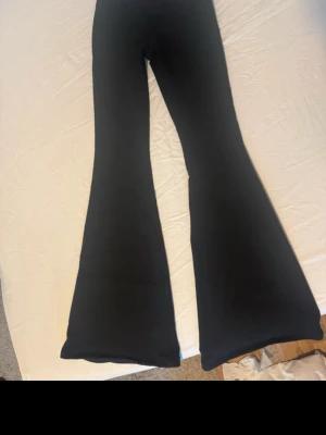 Alobha label jeans Svarta utsvängda jeans - Säljer ett par svarta jeans med riktigt snygg utsvängd passform. Jeansen har hög midja och klassiska fickor bak. Materialet ser ut att vara stretchigt och bekvämt, det är uppsydda så de är 83 cm i innerbenslängd, använda en gång 