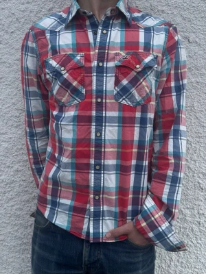 *Retro Hollister skjorta* - En mycket fin skjorta från Hollister. Mycket trevligt mönster med väldigt lyxiga knappar!! Storleken är följande: M.  Modellen är 182 cm och väger 68 kg. Hör av dig vid frågor!
