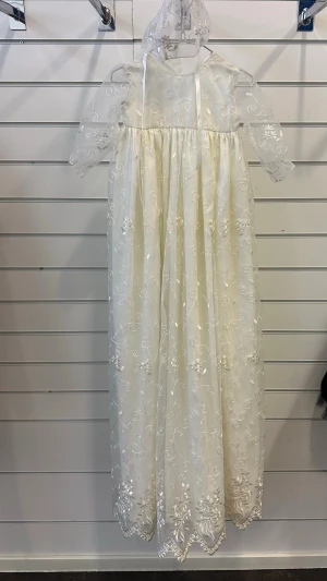 Vit lång dopklänning med spets och broderi till bebis - Elegant vit lång bebis dopklänning med transparenta, broderade spetsärmar och detaljerad spets över hela klänningen. Klänningen har rund halsringning, band i halsen och vackra broderade blommor. Perfekt för dop och en matchande mössa medföljer, aldrig använd. Nypris 2500kr men mitt pris är 900kr och går även att diskuteras vid snabb affär! OBS: FRAKTAR INOM 24H!🩷
