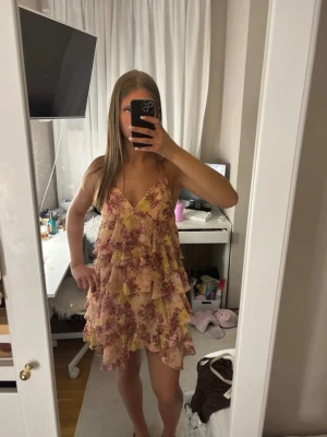 Blommig volangklänning med smala band - Säljer denna jätte fina klänningen med blommor perfekt nu till midsommar eller skolavslutning eller sommarlovet. Är 171 i bilden 