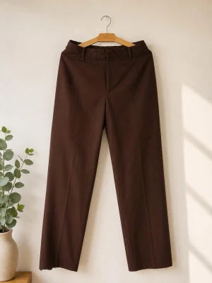 Bruna raka kostymbyxor - Stilrena bruna kostymbyxor med raka ben och klassisk passform. Byxorna har hällor för bälte och pressveck framtill. Perfekta för en clean och snygg look. Materialet ser ut att vara bomullsblandning.