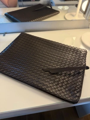 Brunt flätat datorväska - Gina Tricot - Säljer en brun datorväska som är köpt på Gina Tricot. Det stängs med dragkedja och har ett mindre fack inuti, perfekt för pennor med mera. En fin detalj till din outfit och skyddar bra! Hör gärna av dig vid frågor❤️