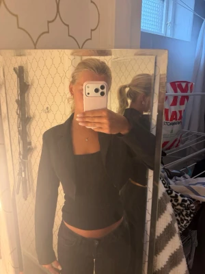 Svart kavaj med klassisk passform - Snygg svart kavaj med klassisk krage och lång ärm. Kavajen har en figurnära passform och är perfekt att styla till både jeans och kjol, från public desire. Enkel och stilren design som funkar till många olika looks.