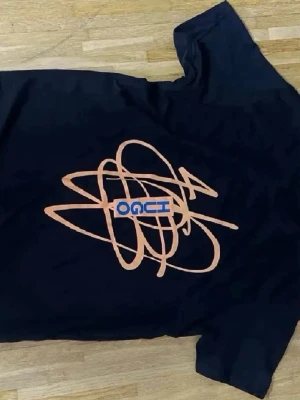 Svart t-shirt med grafiskt tryck - Cool svart t-shirt med ett stort grafiskt tryck i orange och blått på framsidan. T-shirten har korta ärmar och en klassisk passform. Perfekt för dig som gillar streetwear och unika prints.