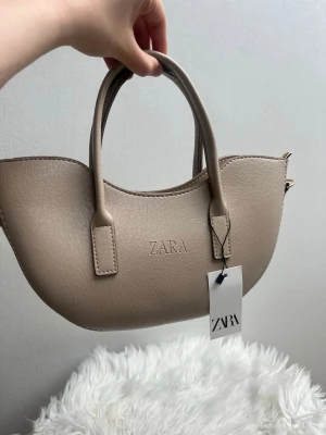 Beige handväska från Zara - Stilren beige handväska från Zara Oanvänd med prislapp