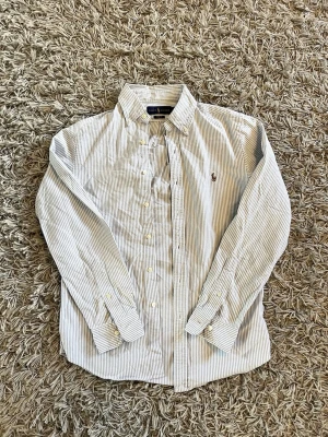 Ralph lauren skjorta - Säljer en vit och blå randig ralphlauren skjorta | Passform är slimfit | Väldigt bra skick | Såklart äkta | Pris 425 | Skriv gärna vid funderingar | 🙌🙌🙌