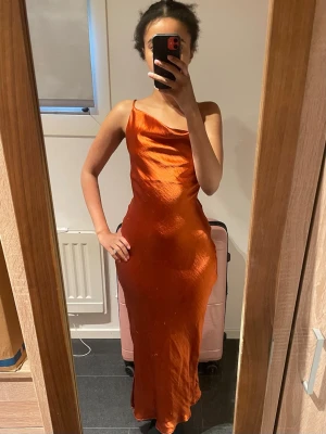 Balklänning  - Satin klänning från ASOS köpt 2022 och använd vid 2 tillfällen💕 Den har en fläck som syns i vissa ljus. Den har även små tråddragningar vid sidan. Därav lågt pris. Storlek XS! Banden går att justera hursomhelst !