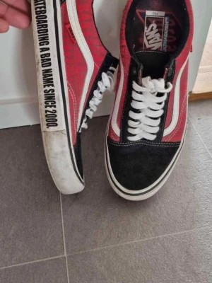 Vans Old Skool röd/svart/vit sneaker - Klassiska Vans Old Skool sneakers i rött, svart och vitt med vit sula och svart text på sidan. Skorna har vit sidestripe, svarta tåpartier och vita skosnören. Ovandelen är i canvas och mocka, perfekt för en streetwear-look.Snygga speciella vans skor, köpta från usa i vintras, använt 2 gånger. Storlek 44,5 Köptes för 1499kr.