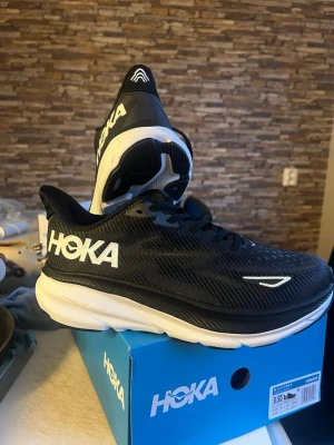 Hoka Clifton 9 - Snygga svarta Hoka sneakers med vit och svart sula. Helt nya och og kartongen följer med om man önskar det. Denna är i storlek 44 men jag har även 36 och 48