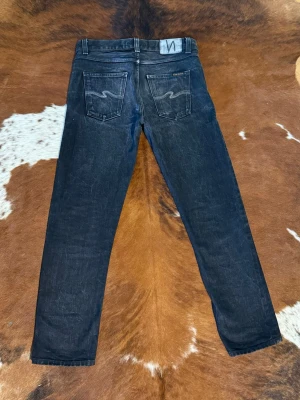 Nudie jeans GrittyJackson rainbow black selvage - Tjena! Säljer dessa riktigt snygga nudie jeans med svart/vit regnbågs embo, fint skick i storlek W29/L30, hör av dig vid funderingar!  Bild 3 är inte samma par jeans utan dom är bara med så att man ska se hur byxorna åldras/ ser ut på!