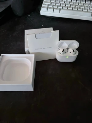 Apple AirPods 4 (ANC) med laddningsetui - Säljer ett par vita Apple AirPods 4 (ANC) med trådlöst laddningsetui. Snygg och stilren design i plast, perfekt för dig som vill ha grymt ljud och brusreducering. Kommer med originalförpackning och tillbehör.