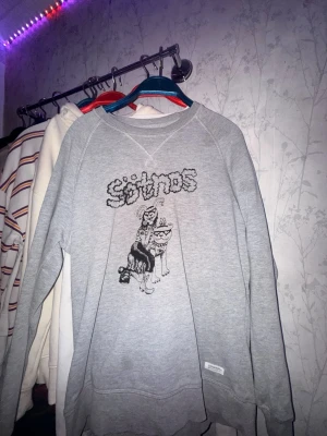 Grå sweatshirt sötnos merch - Grå sweatshirt som är sötnos merch. Tröjan har rund halsringning och är långärmad, perfekt för en avslappnad och trendig look.