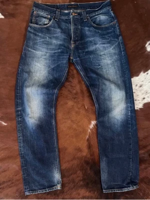 Mörkblå jeans från Nudie Jeans - Tjena, säljer nu detta schyssta paret nudie jeans i modellen Sharp Bengt, jeansen är i gott skick med riktigt go tvätt. Storlek W34/L32, hör av dig vid funderingar