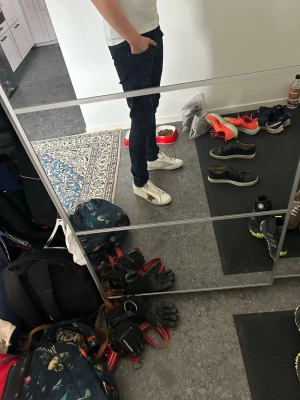 Golden Goose vita sneakers - Golden Goose sneakers i vitt läder med gr oliv sopatch på sidan och gulddetal land på plösen. sopatchen ger en unik och trendig look. Perfekta för dig som gillar streetwear och vill sticka ut.