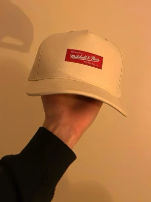 Beige keps från Mitchell & Ness - Jättefin helt oanvänd beige keps från Mitchell & Ness med klassisk rak skärm.