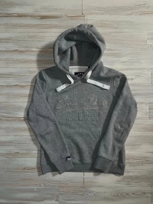 grå Superdry hoodie - Säljer denna feta gråa superdry hoodie i fint skick. måtten är längd: 62cm bredd: 53cm🤩 inga fel eller nåt sånt🤗 Hör gärna av er vid funderingar samt snabbaffär🙌🏻