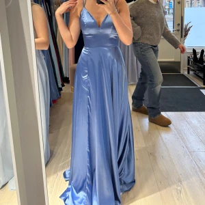 Balklänning - Blå balklänning från Ivoryfield Använd två gånger av mig och en tidigare användare. Nypris 3300kr Storlek 36 Jag är 165 cm. Slits framtill, klänningen är uppsydd efter efter min längd och även insydd i midjan då den var lite uttänjd vid köpet. Jag skulle alltså säga att den passar någon som normalt sett har storlek 36. Den har snöring bak i ryggen där man kan anpassa klänningen efter sin egna form. Klänningen är kemtvättad sedan användning (kvitto finns). 